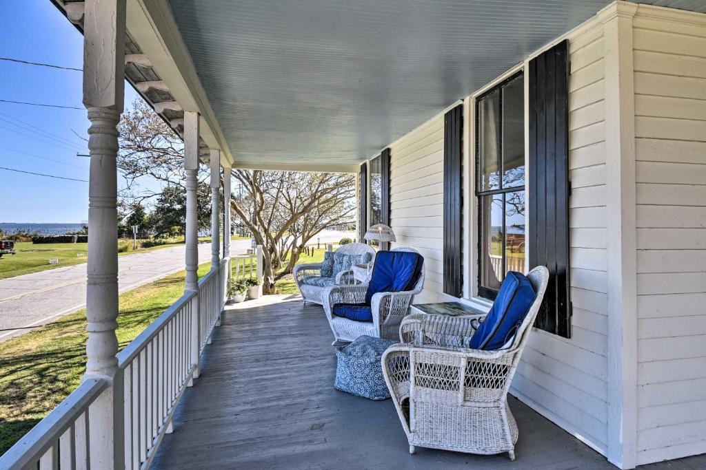 eine Veranda mit Stühlen und Tischen auf einem Haus in der Unterkunft Cozy Currituck Home with Fire Pit near Ferry! in Currituck