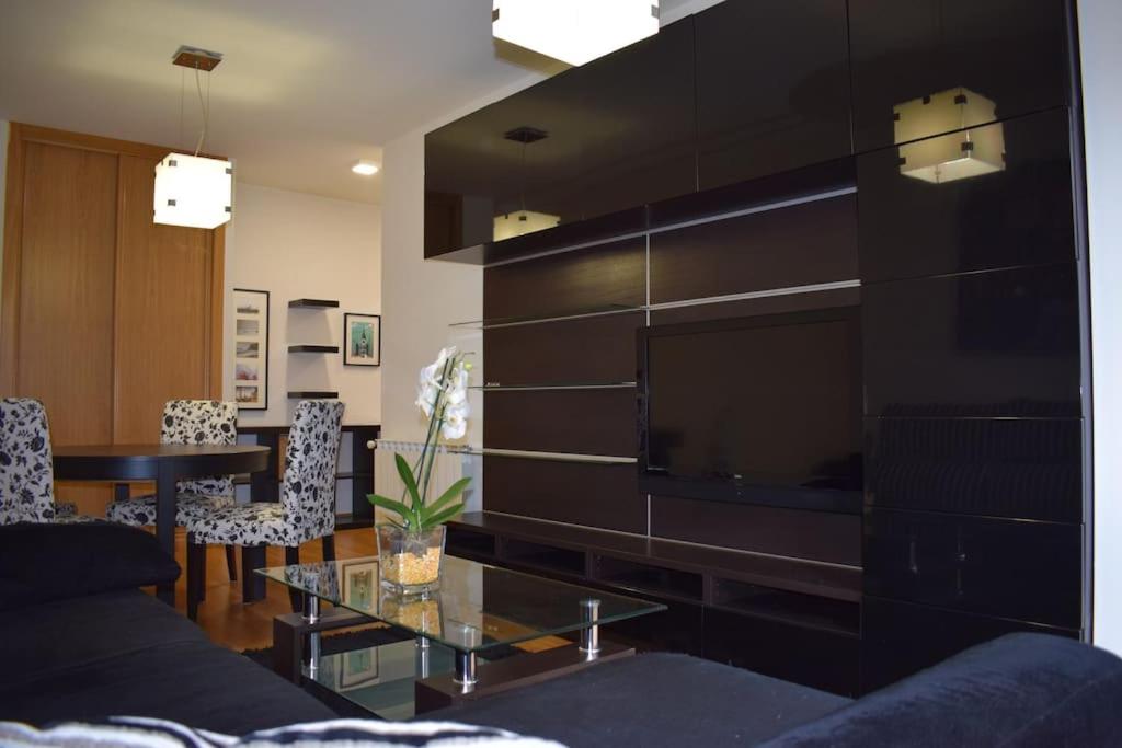a living room with a couch and a large television at Apartamento centro Villagarcía. in Vilagarcia de Arousa