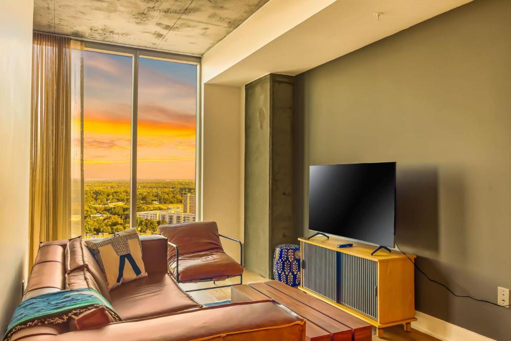uma sala de estar com um sofá e uma televisão de ecrã plano em Longview at the Rainey District em Austin