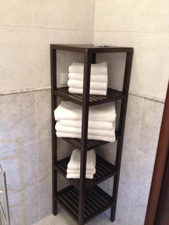 a black towel rack with white towels in a bathroom at Via Roma suite in Ortona