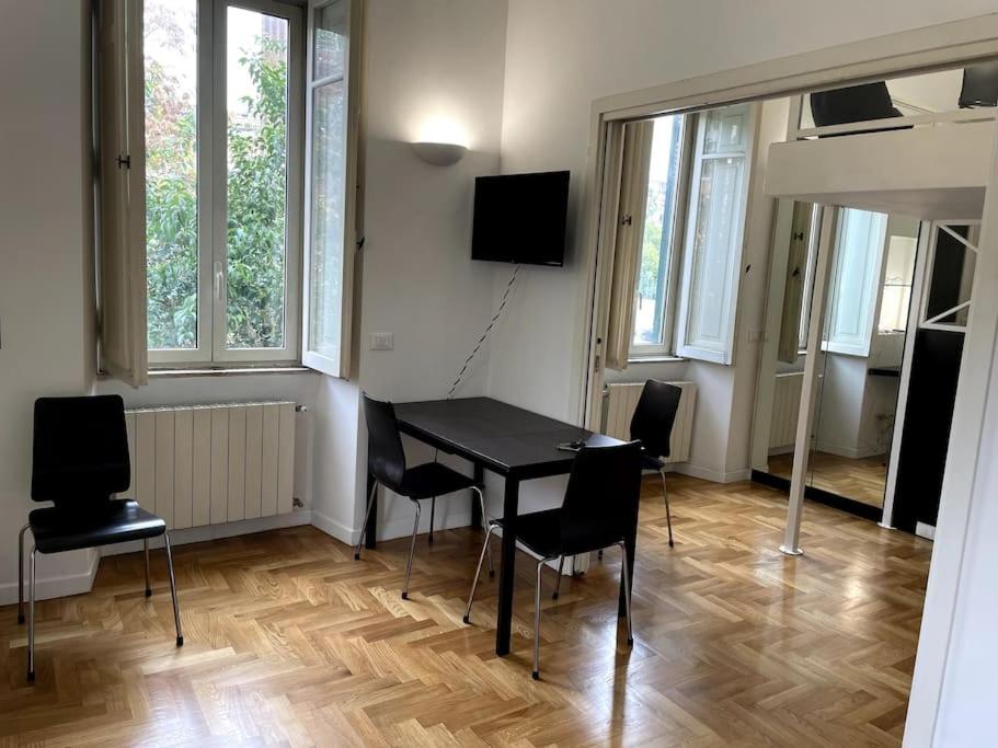 ein Esszimmer mit einem schwarzen Tisch und Stühlen in der Unterkunft Ponte Milvio Smart Appartamento in Rom