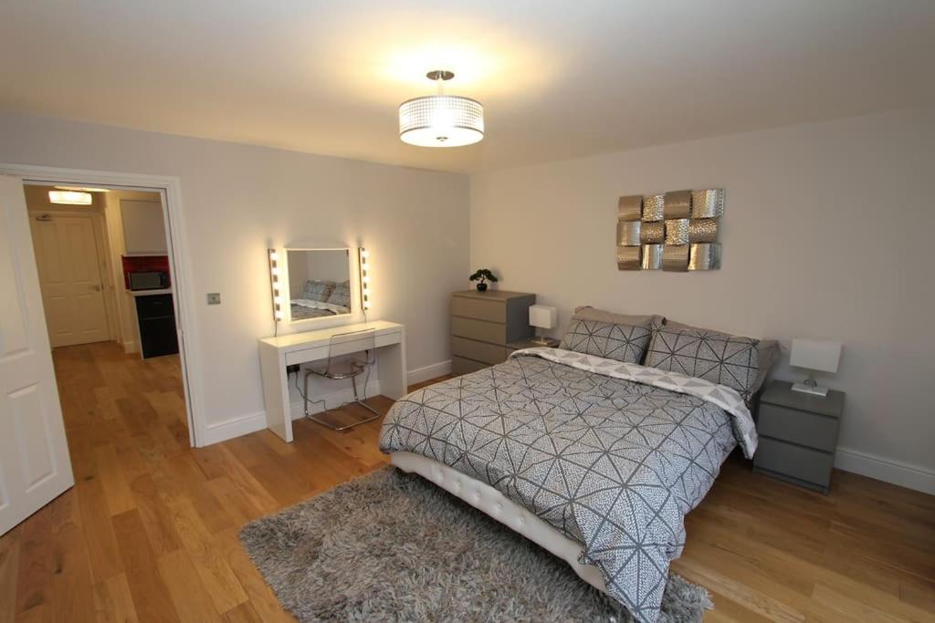 a bedroom with a bed and a desk and a mirror at Lovely One Bed Apartment-Near All Transport-Village-FreeParking in London