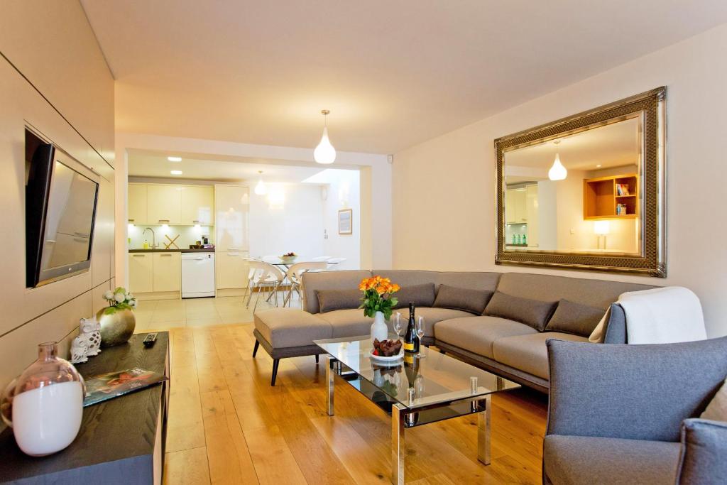 un soggiorno con divano e tavolo di 2 Bed Mews House Marylebone a Londra