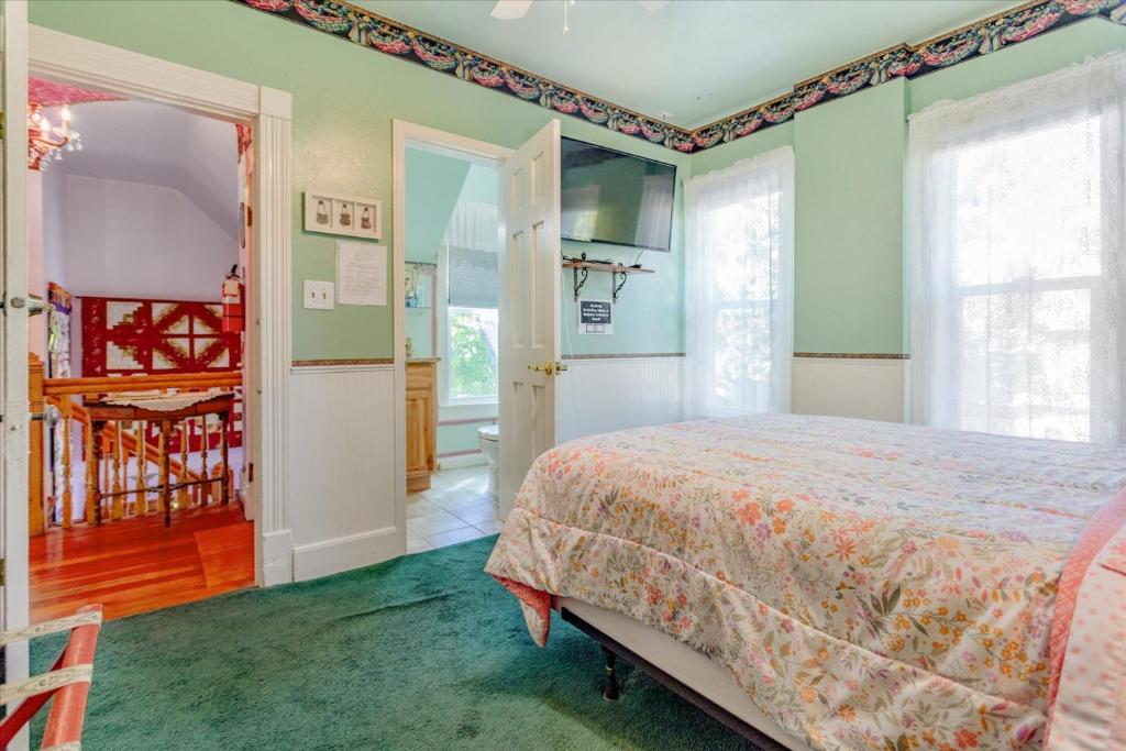 a bedroom with a bed and green walls at The Silk Pincushion in Golden