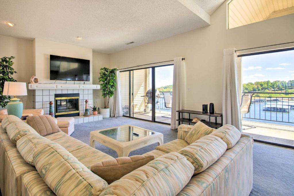 a living room with a large couch and a fireplace at Bright Waterfront Condo with Resort Amenities! in Lake Ozark