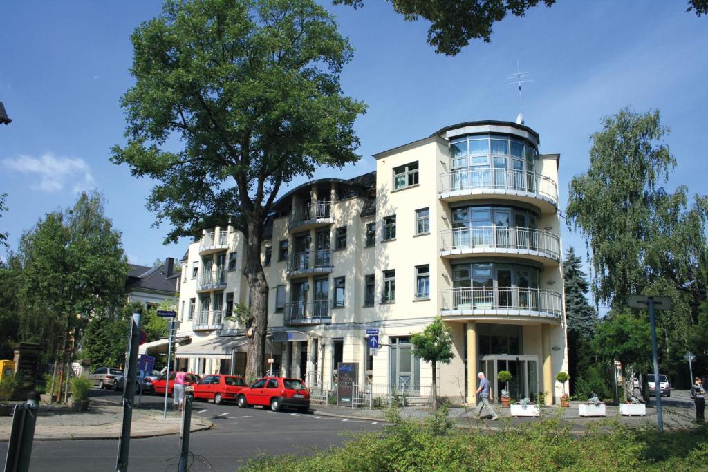a white building on the corner of a street at Hotel Am Blauen Wunder in Dresden