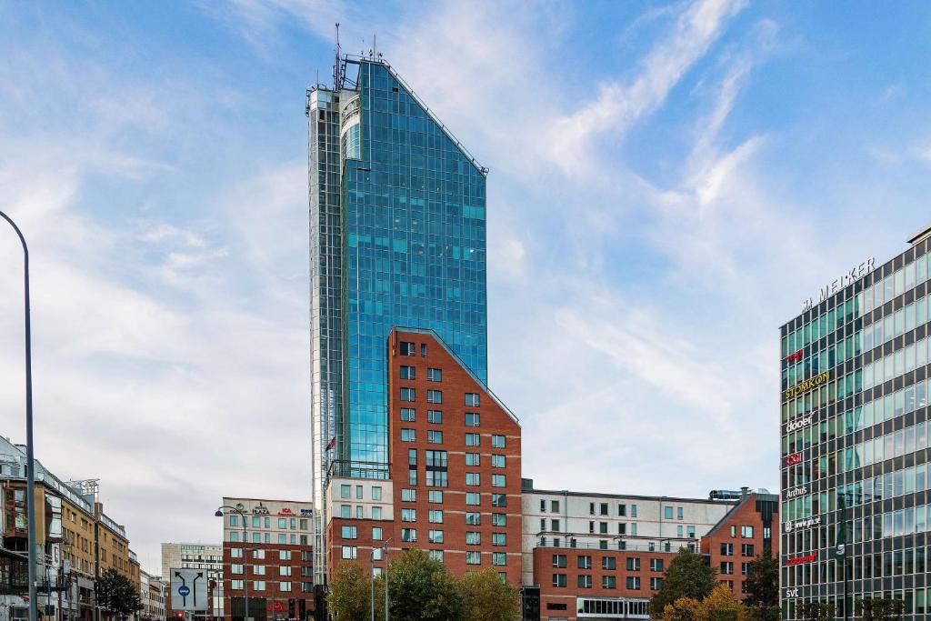 un grand bâtiment en verre dans une ville avec des bâtiments dans l'établissement Best Western Plus Hotel Plaza, à Västerås