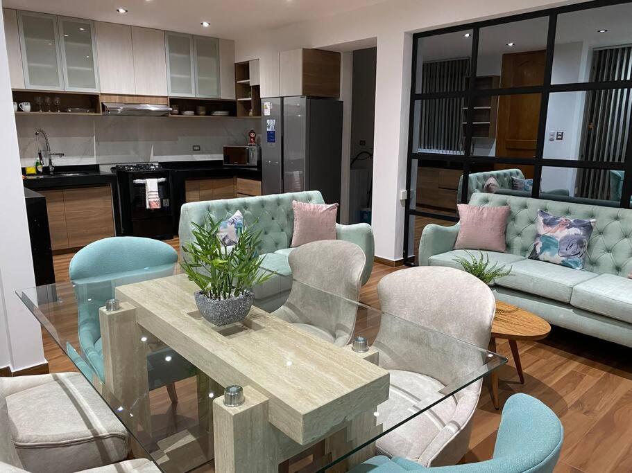 een woonkamer met een glazen tafel en stoelen bij Turista en casa Apartamento con 100 m2 in Lima