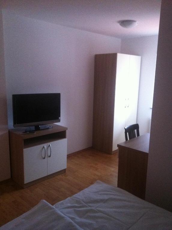 Pokój z telewizorem na szafce i łóżkiem w obiekcie Lugarnica w Zagrzebiu