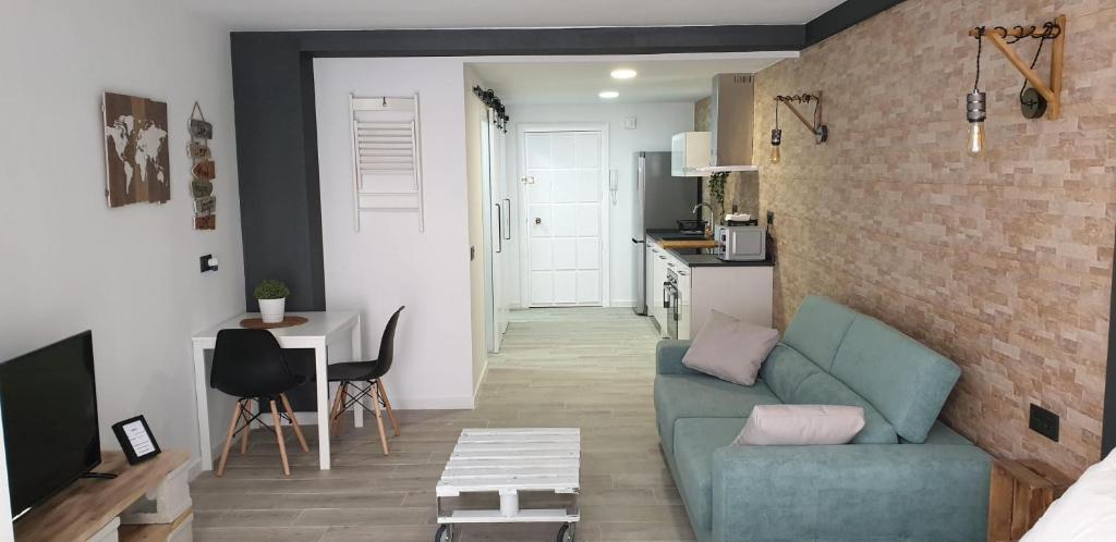 a living room with a blue couch and a brick wall at Reformado Apartamento - Centro Alicante in Alicante