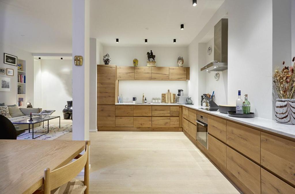 eine Küche mit Holzschränken und ein Wohnzimmer in der Unterkunft ApartmentInCopenhagen Apartment 1476 in Kopenhagen