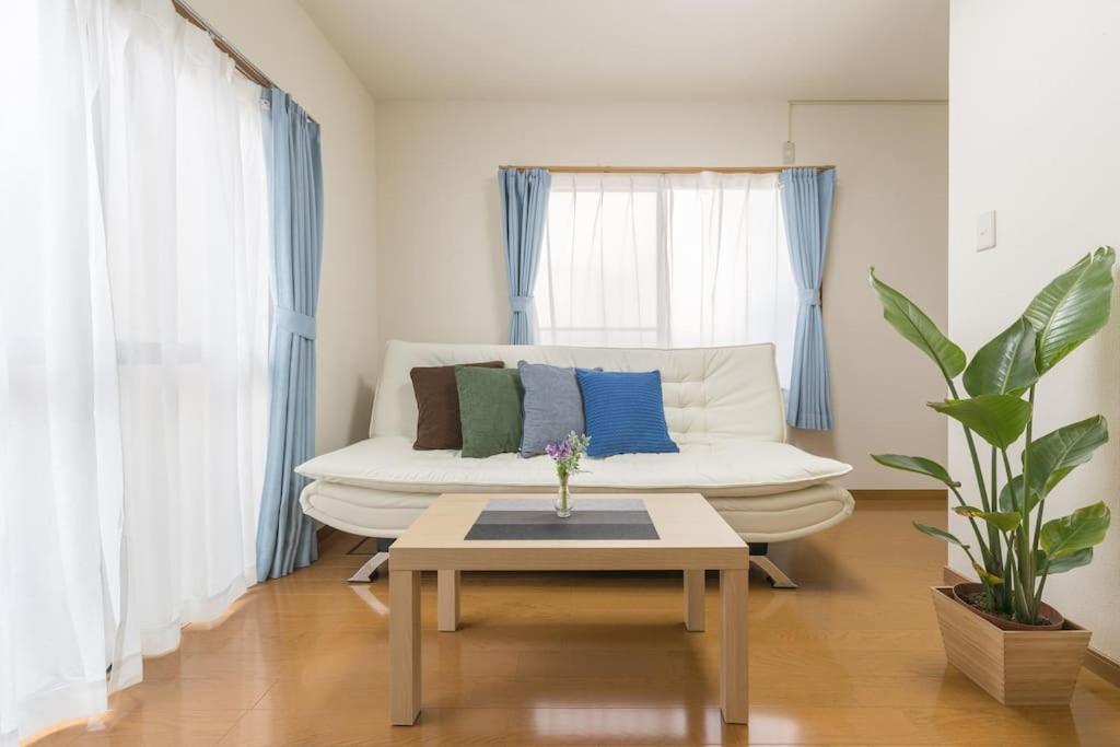 sala de estar con sofá blanco y mesa en Shinjuku12min Shibuya15min Max10ppi Free-Wifi en Tokio