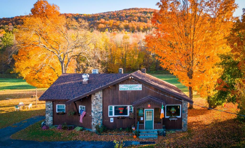 a cabin in the middle of a field with autumn trees at Jimmy OConnor's Windham Mtn Inn in Windham