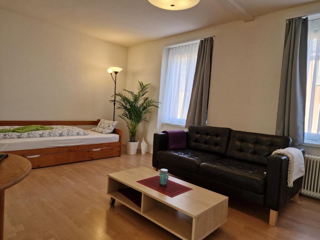 a living room with a couch and a bed at Bastis Family Apartment in Luzern