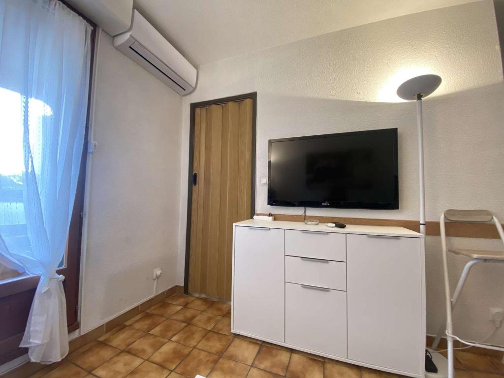 a living room with a television on a white cabinet at Appartement Sainte-Maxime, 2 pièces, 4 personnes - FR-1-226-500 in Sainte-Maxime