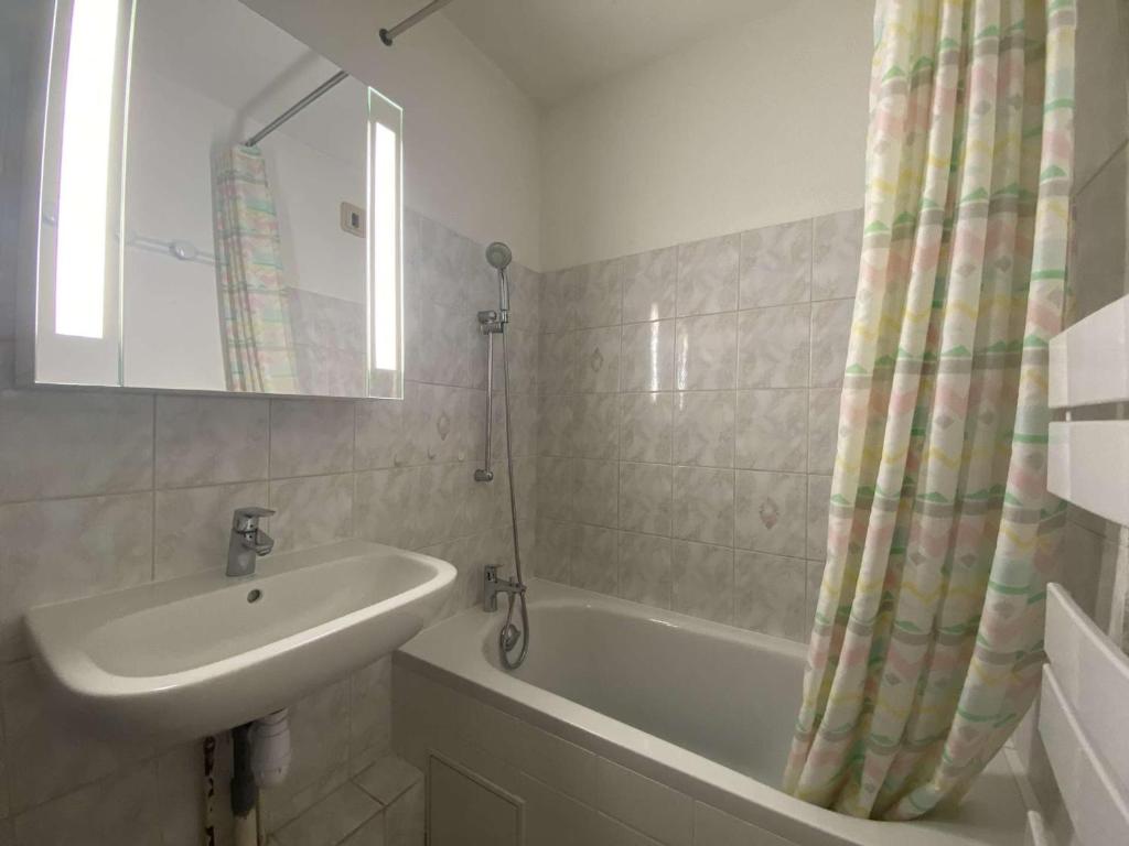 a bathroom with a sink and a tub and a mirror at Appartement Sainte-Maxime, 2 pièces, 4 personnes - FR-1-226-500 in Sainte-Maxime