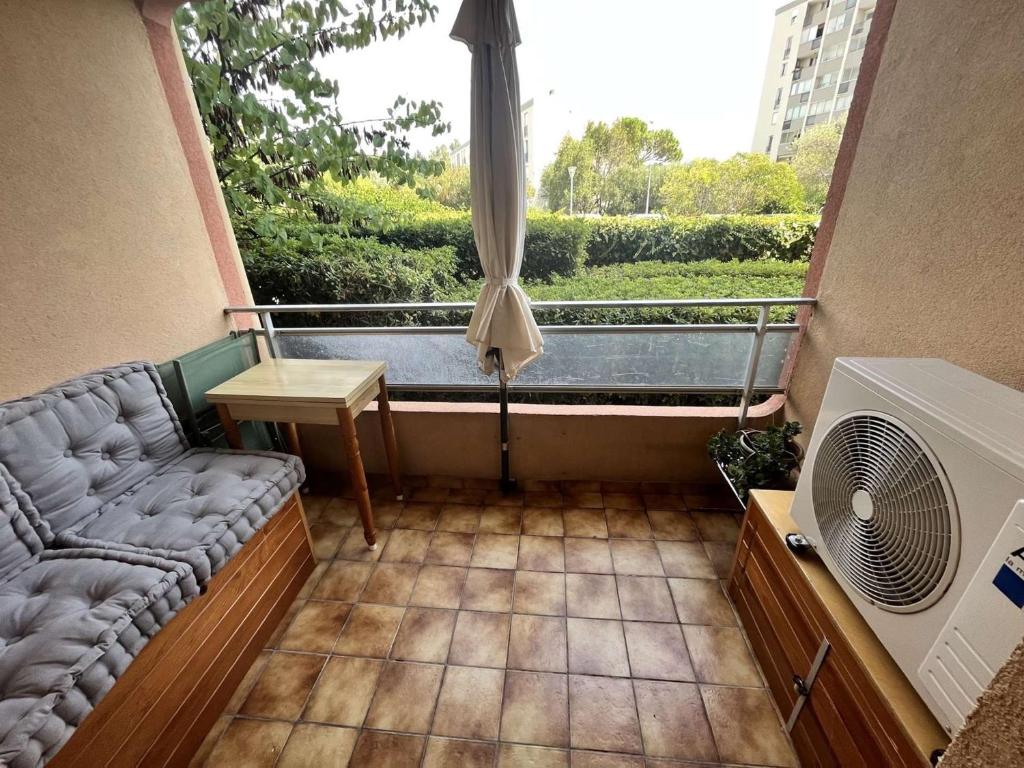 a small balcony with a couch and a window at Appartement Sainte-Maxime, 2 pièces, 4 personnes - FR-1-226-500 in Sainte-Maxime