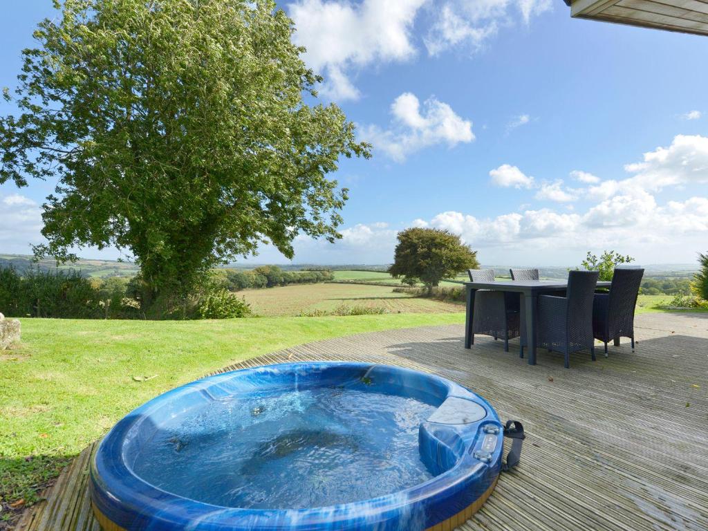 a hot tub sitting on a deck with a table at 10 Horizon View in Liskeard