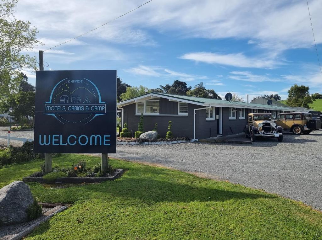 a sign in front of a house with a welcome sign at Cheviot Motels, Cabins and Camp in Cheviot
