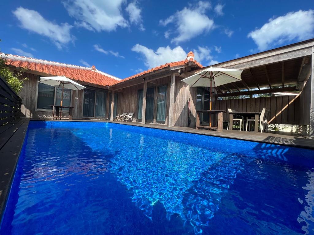 a swimming pool with blue water in front of a house at Villa Muse Okinawa- Vacation STAY 43827v in Nago