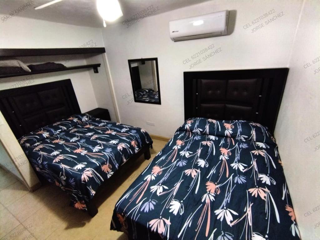 deux lits côte à côte dans une chambre dans l'établissement Condominio 231 Loma Bonita, enfrente de la alberca!, à San Carlos