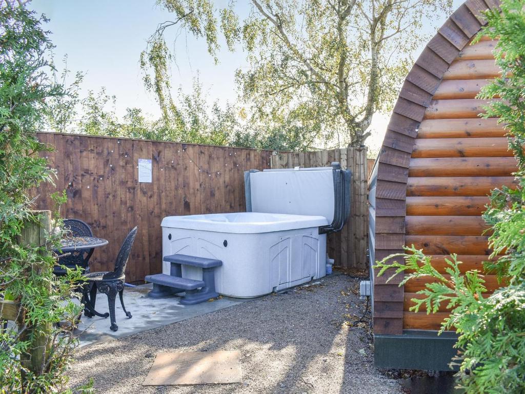 une cour avec un bain à remous et une clôture dans l'établissement Privet Pod - Uk41394, à Westhead