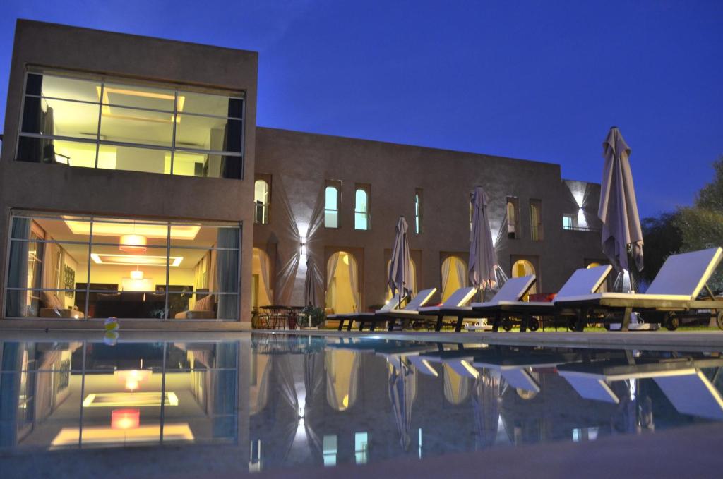 a swimming pool with lounge chairs next to a building at Villa Loanaelle in Marrakesh