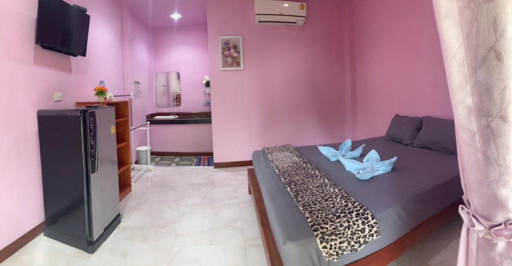 Una habitación púrpura con una cama con flores azules. en PK Family House en Ko Mook