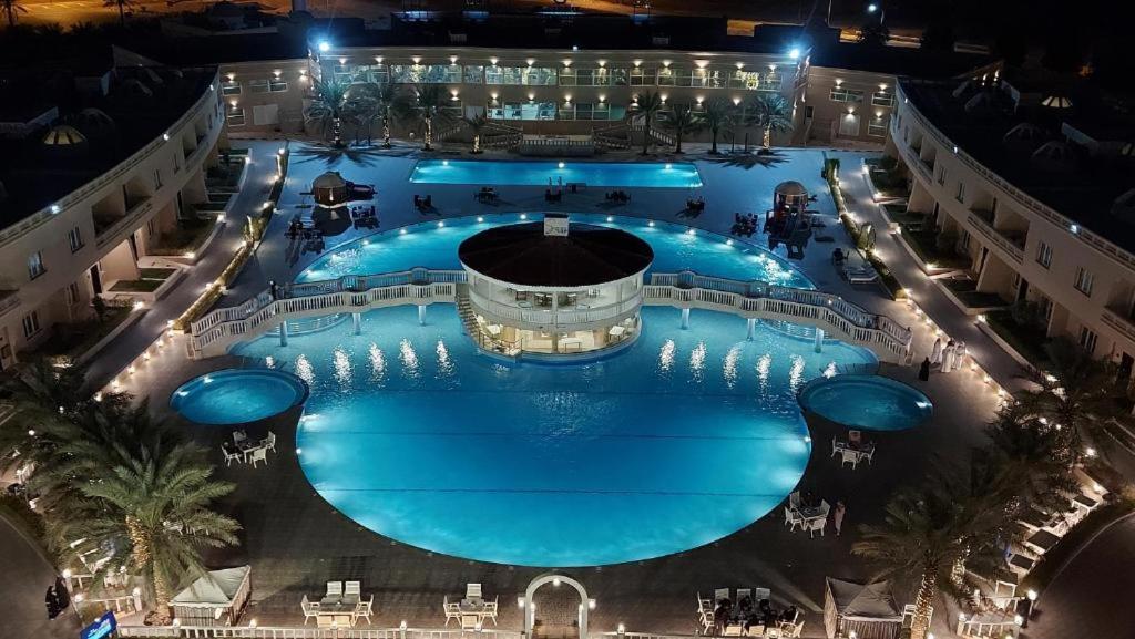 an overhead view of a large swimming pool at night at Al Salam Grand Hotel in Al Buraymī