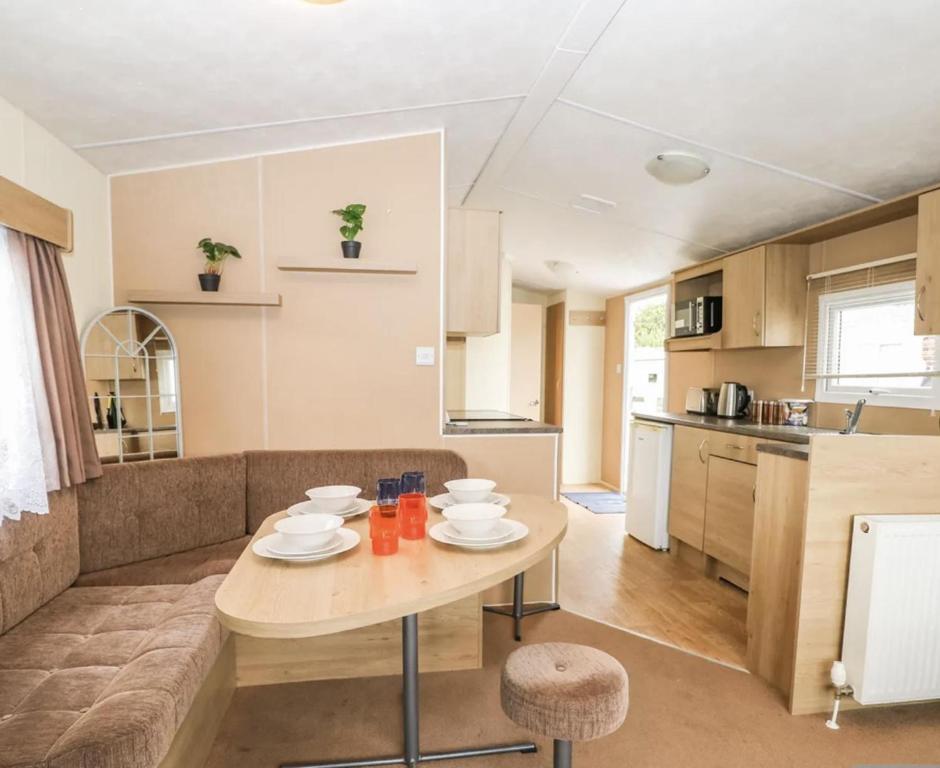 een keuken en een woonkamer met een tafel en een bank bij Charming and peaceful 2-Bed Chalet in Hampshire in Warsash
