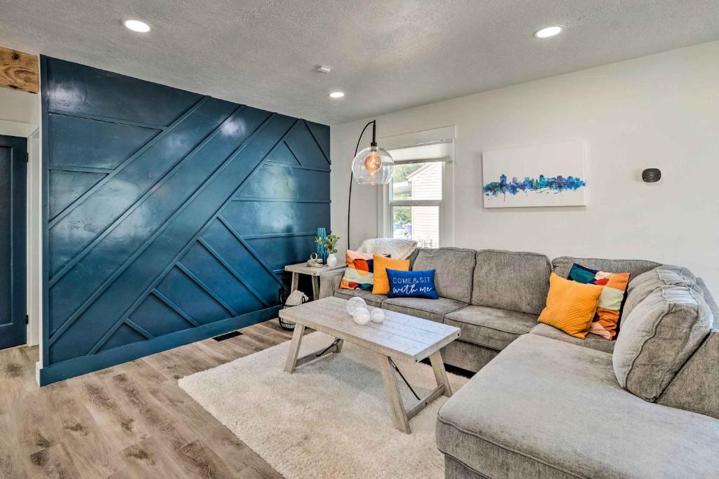 sala de estar con sofá y pared azul en Cozy and Modern SLC Home Yard, 6 Mi to Dtwn!, en Salt Lake City