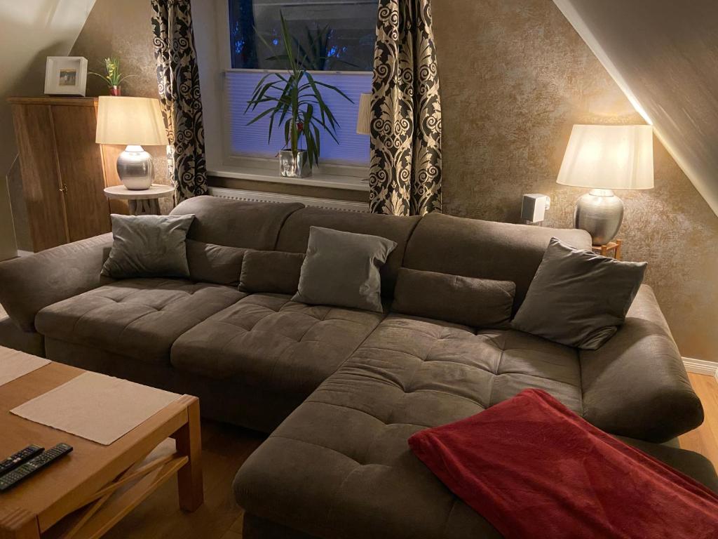 sala de estar con sofá marrón y mesa en Hoch Hamburg, ein Traum unterm Dach, en Geesthacht