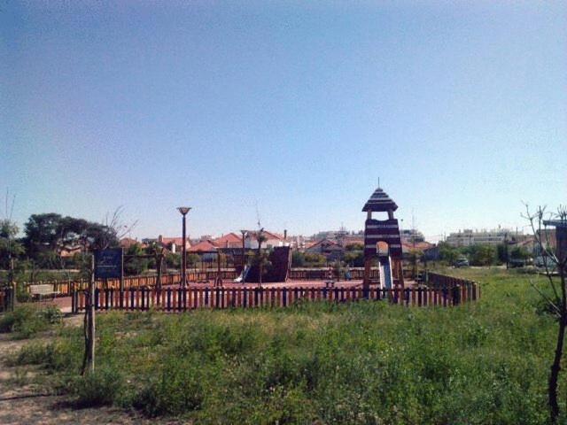 a playground with a clock tower in a field at Hotel Residencial Colibri in Costa da Caparica