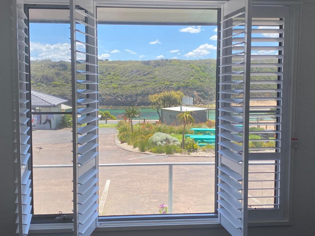 an open window with a view of a beach at Southern Ocean Motor Inn in Port Campbell