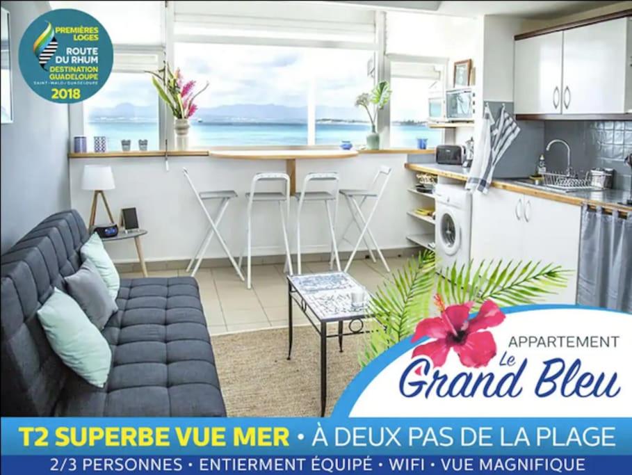 un salon avec un canapé et une cuisine dans l'établissement Grand bleu-Superbe T2 vue mer & accès plage, au Gosier
