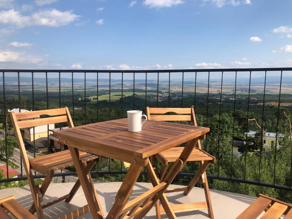d'une table et de chaises en bois sur un balcon avec vue. dans l'établissement Apartmán Pekná Vyhliadka - Vila Vlasta, à Vysoke Tatry - Horny Smokovec