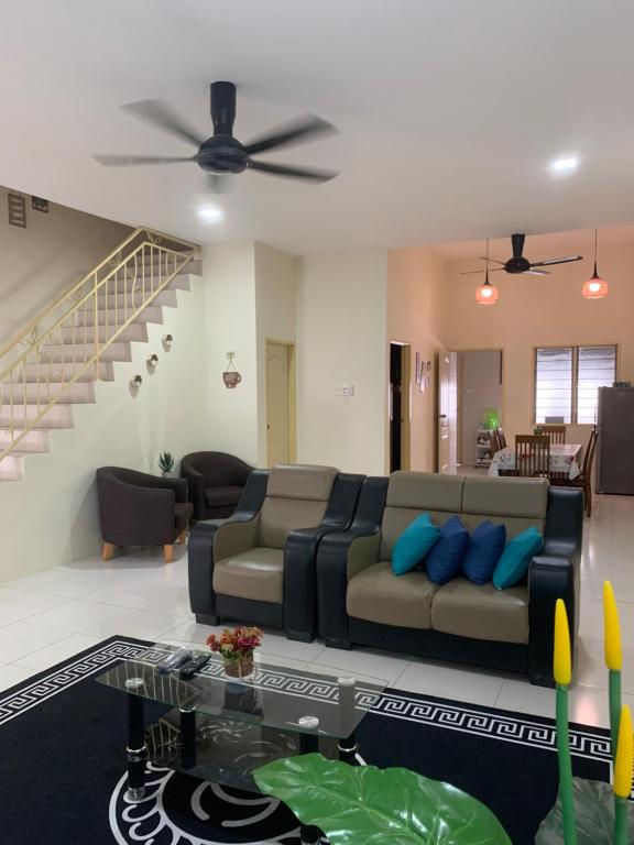 a living room with a couch and a ceiling fan at ZillQayyim Homestay in Seri Iskandar