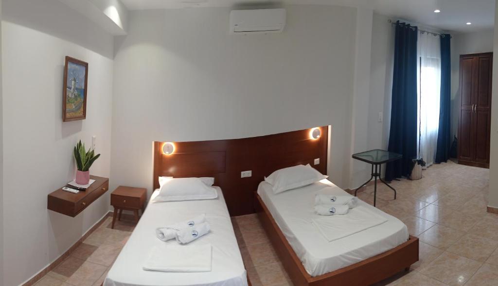 1 dormitorio con 2 camas con sábanas blancas en Kasos Palace en Frý