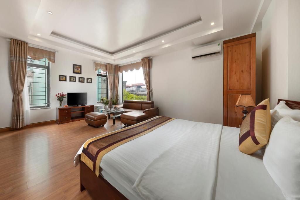 a bedroom with a large bed and a living room at Airport Transit Hotel in Hanoi