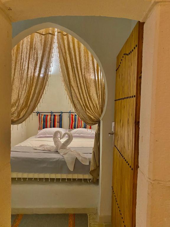 two swans are sitting on a bed in a bedroom at Hôtel Djerba Authentique - Au centre de Midoun in Midoun