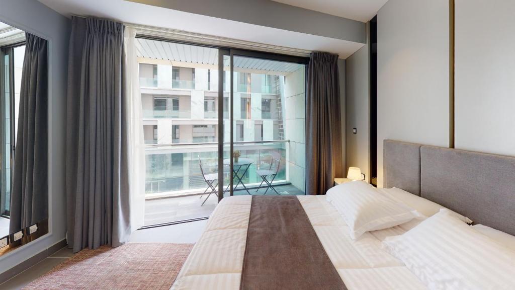 a bedroom with a large bed and a large window at Al Fares Luxury furnished Apartment-Damac Tower in Amman