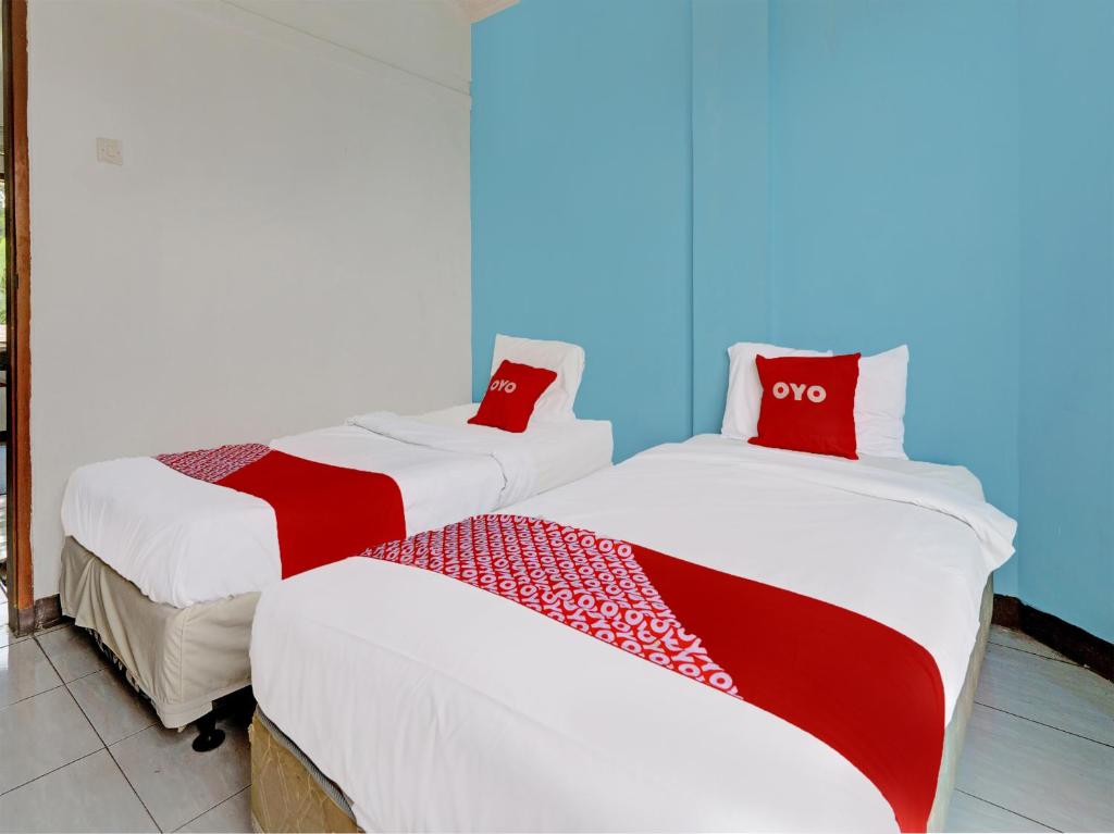 two beds sitting next to each other in a room at Super OYO Capital O 91810 Hotel Balebat 2 in Bandung