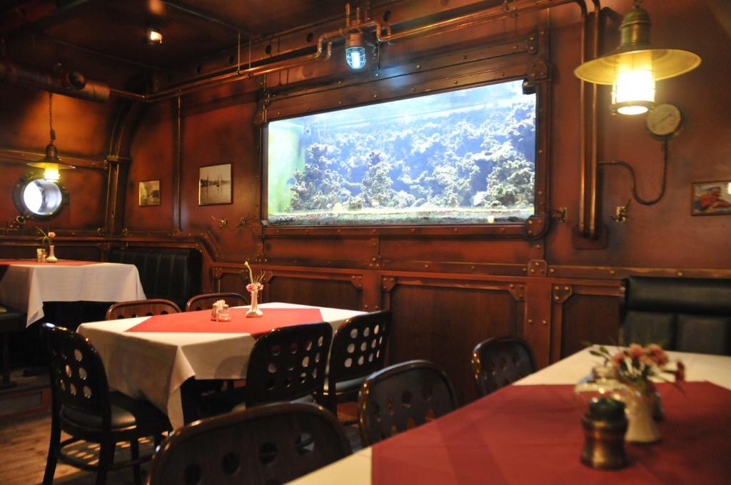 a restaurant with tables and chairs and a large window at U-Nautic Restaurant &amp; Pension in Waren