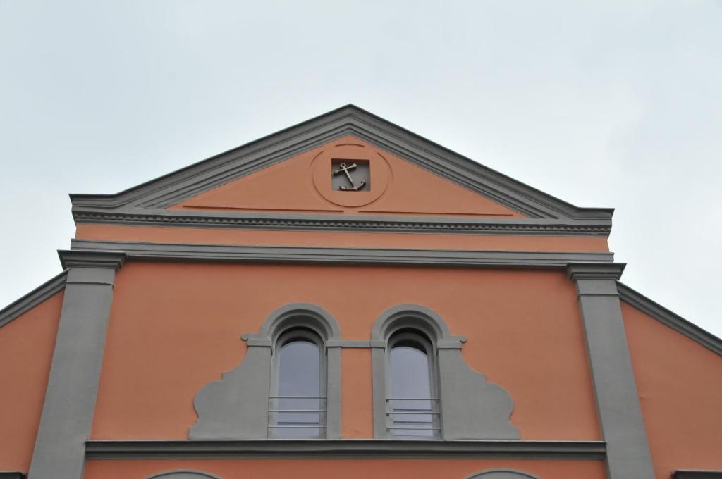 an orange building with a clock on top of it at U-Nautic Restaurant &amp; Pension in Waren