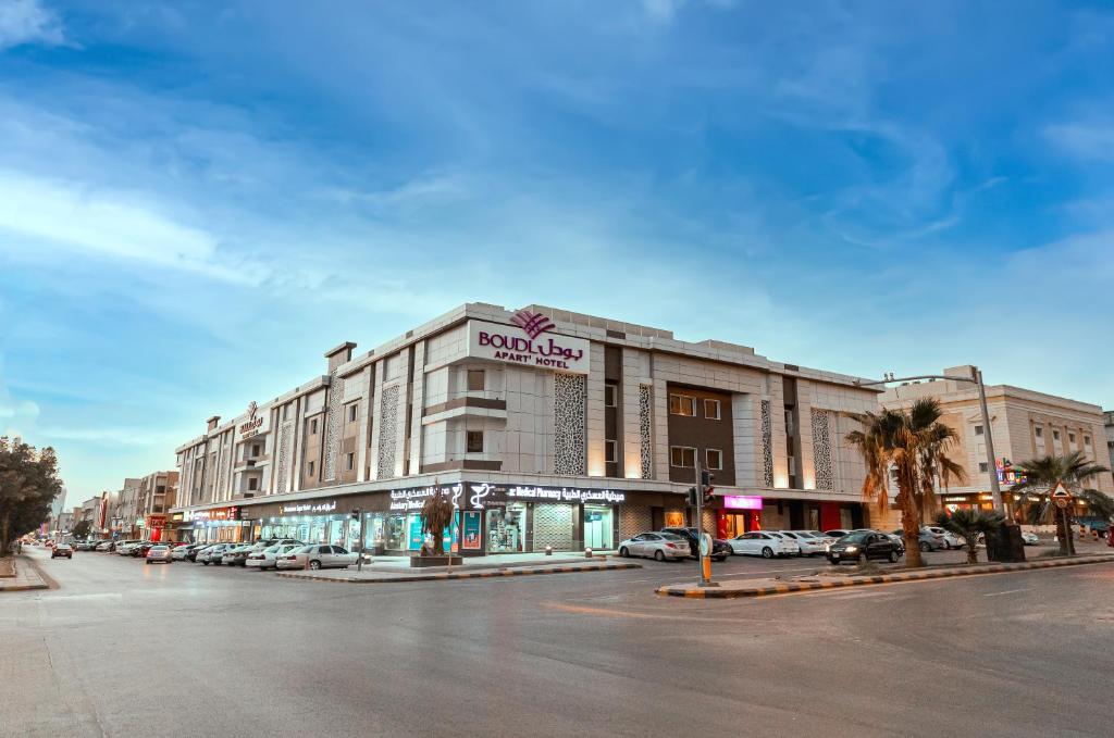 un gran edificio con coches estacionados en un estacionamiento en Boudl Al Sulimanyah en Riad