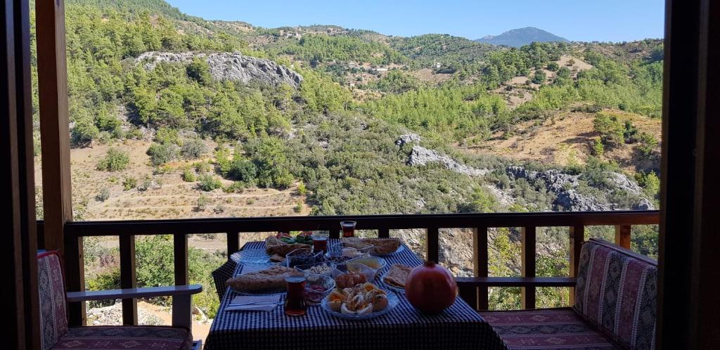 a table on a balcony with a view of a mountain at Hergül Holiday Village in Gazipasa
