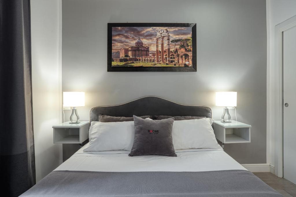 ローマにあるRhome Guest Houseのベッド(ランプ2つ、上に絵画付)