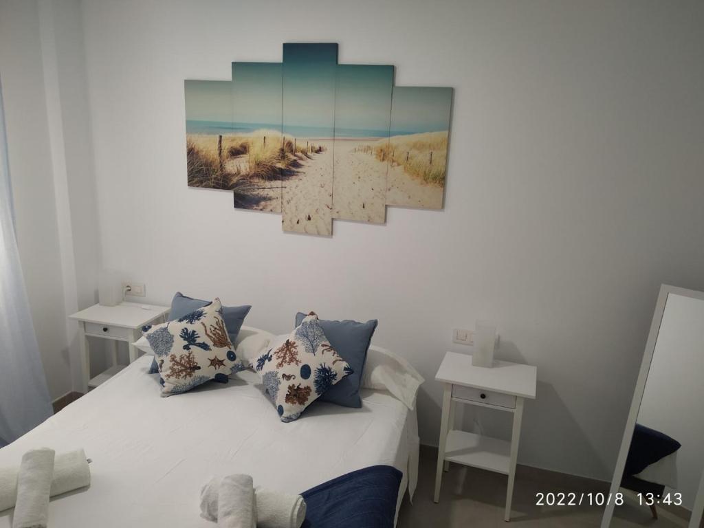 een slaapkamer met een bed met een schilderij aan de muur bij Brisas del Medano in El Médano