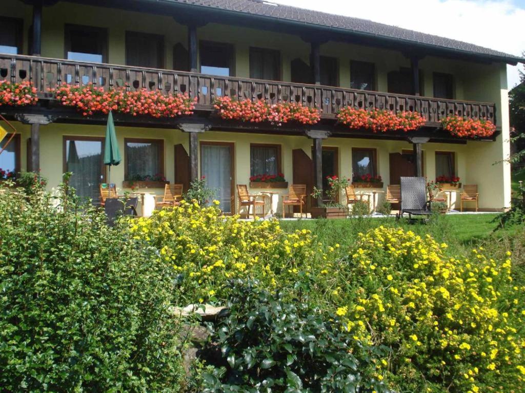a building with a balcony with flowers on it at Pension Einsiedelei in Zwiesel