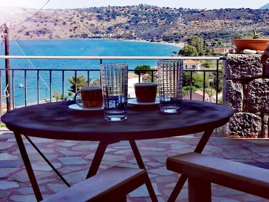een tafel op een balkon met uitzicht op de oceaan bij Kamares View in Ayeranós